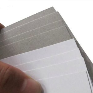 A stack of HiQ Duplex Greyback board showing the white coated front and grey reverse.