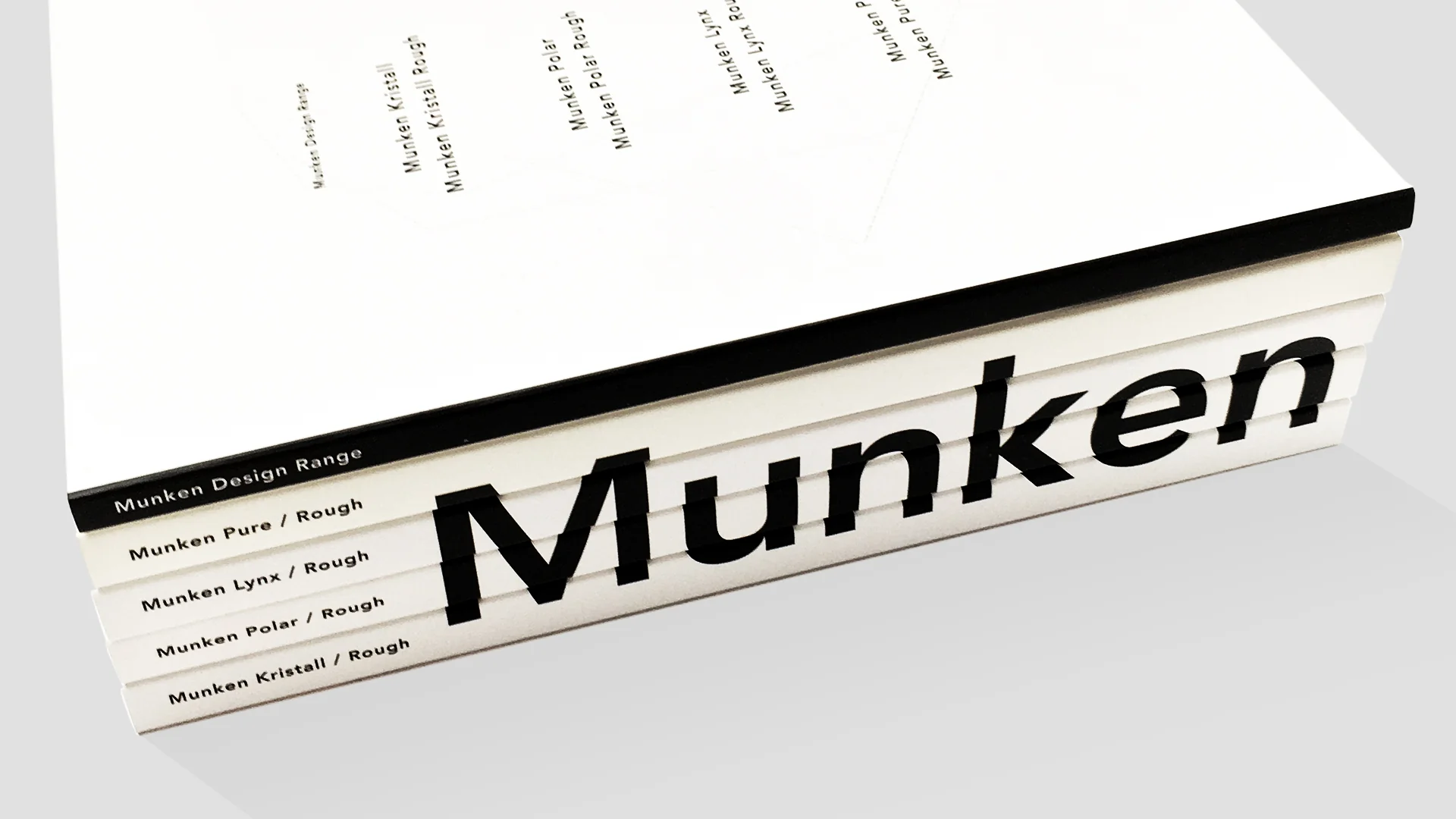 A variety of Munken Collection paper swatches showing different weights and shades.