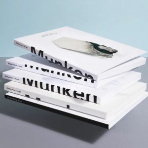 A stack of books featuring the creamy, tactile pages of Munken Design paper.