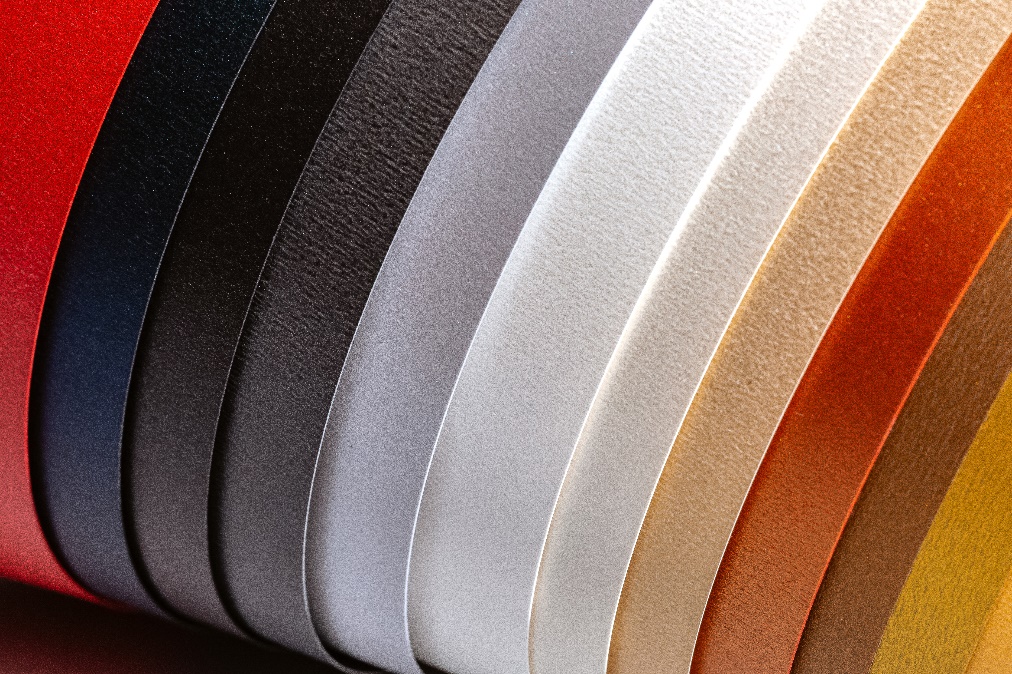 A shimmering sheet of Neenah Pearl paper catching the light with its metallic finish.